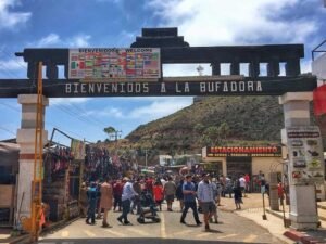 Tourists browsing souvenirs and interacting with vendors at the La Bufadora Ensenada market.